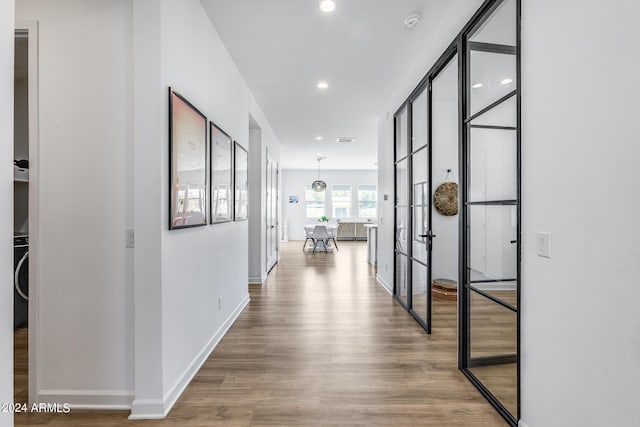 hallway with washer / clothes dryer and hardwood / wood-style floors