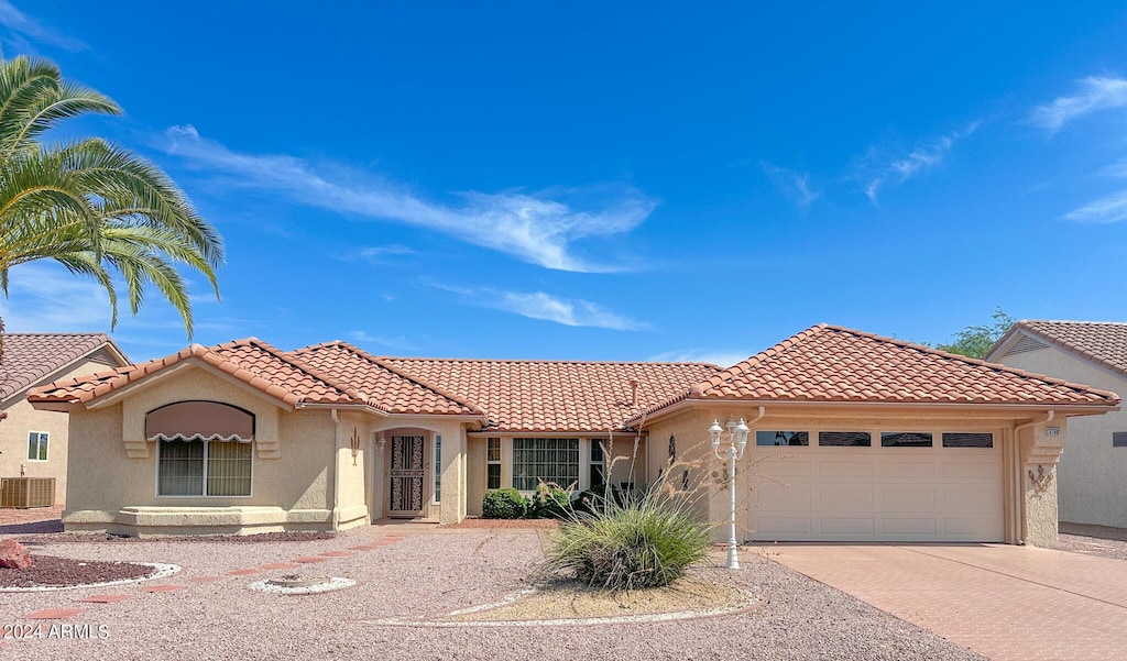 mediterranean / spanish-style home with a garage and cooling unit