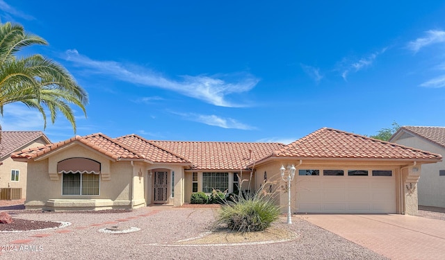 mediterranean / spanish-style home with a garage and cooling unit