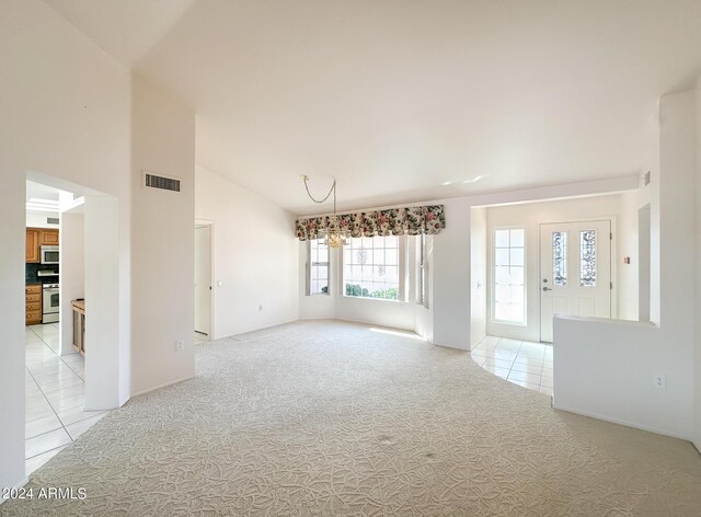 unfurnished living room featuring lofted ceiling and light carpet