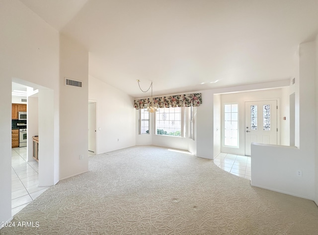 carpeted empty room with high vaulted ceiling