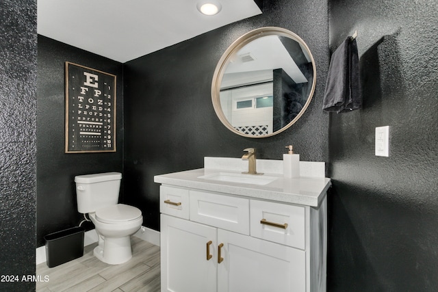 bathroom featuring toilet, hardwood / wood-style floors, and vanity