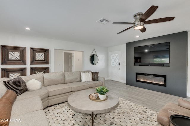 living room with ceiling fan and light wood-type flooring