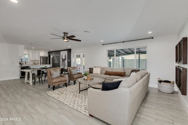 living room with ceiling fan and light hardwood / wood-style floors