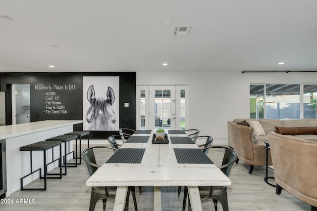 dining space with light hardwood / wood-style floors and french doors