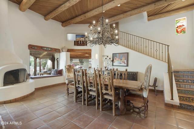 dining room with a fireplace, wooden ceiling, beam ceiling, tile patterned floors, and an inviting chandelier