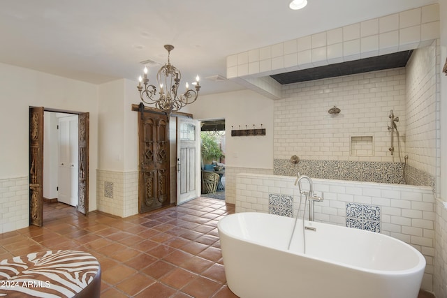 bathroom with a washtub, tile patterned flooring, tile walls, and an inviting chandelier