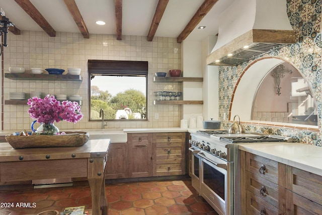 kitchen with sink, high end stove, decorative backsplash, custom exhaust hood, and beamed ceiling