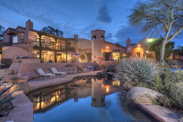 pool at dusk featuring a patio area