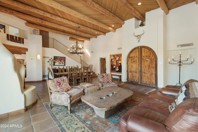 living room with wood ceiling, a chandelier, beamed ceiling, tile patterned flooring, and a high ceiling