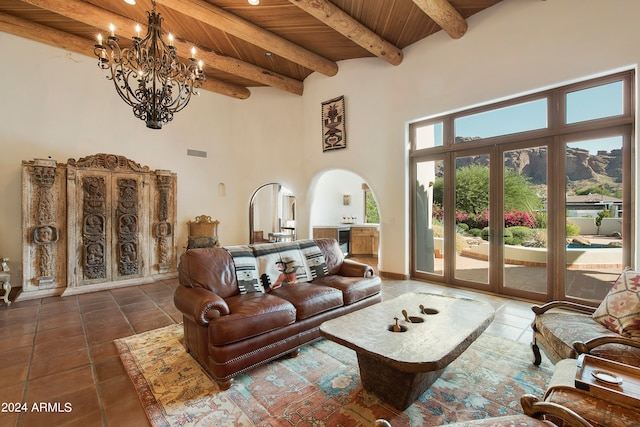 living room featuring wood ceiling, an inviting chandelier, dark tile patterned floors, beamed ceiling, and a high ceiling