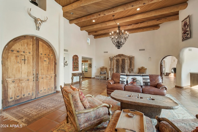 tiled living room with beam ceiling, a chandelier, a high ceiling, and wooden ceiling