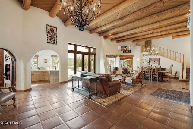 tiled living room with beam ceiling, a towering ceiling, wooden ceiling, and a chandelier