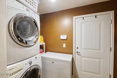 clothes washing area featuring stacked washer and dryer