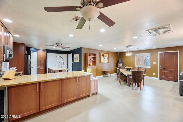 kitchen with beverage cooler, light stone countertops, a textured ceiling, and appliances with stainless steel finishes