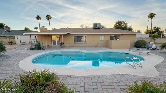 view of swimming pool with central AC unit and a patio