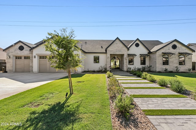 french country inspired facade featuring a front yard and a garage