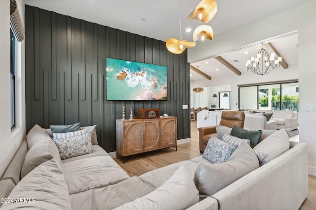 home theater room with a chandelier, light hardwood / wood-style floors, beamed ceiling, and wooden walls