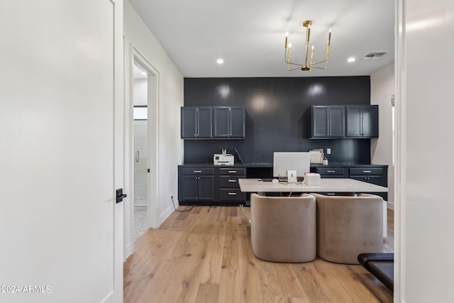 kitchen featuring a chandelier, tasteful backsplash, hanging light fixtures, and light hardwood / wood-style flooring