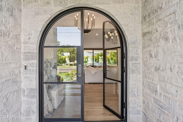 doorway to outside featuring a notable chandelier