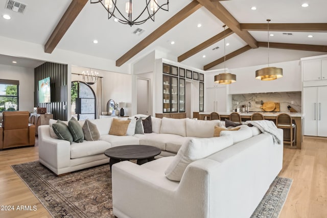 living room featuring beam ceiling, light hardwood / wood-style floors, and plenty of natural light