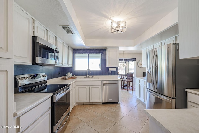 kitchen featuring an inviting chandelier, sink, white cabinets, and appliances with stainless steel finishes