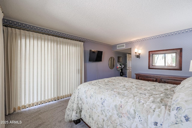 bedroom with a textured ceiling and carpet flooring