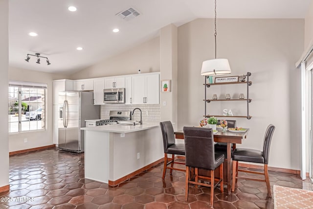 925 W Hudson Way, Gilbert, AZ 85233 - kitchen with appliances with stainless steel finishes, vaulted ceiling, a peninsula, white cabinets, and light countertops