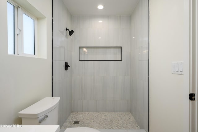 bathroom with toilet and tiled shower