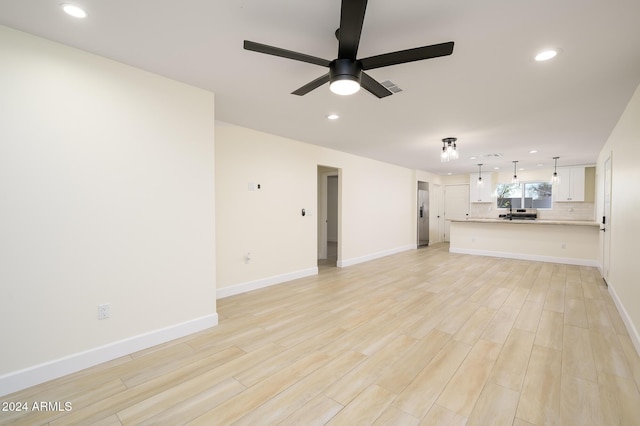 unfurnished living room with ceiling fan and light hardwood / wood-style floors