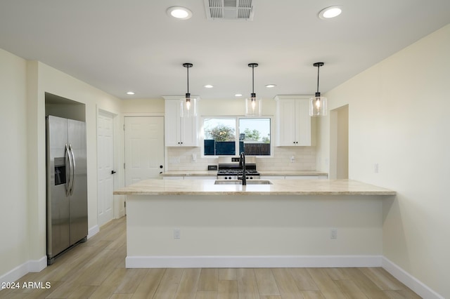 kitchen with white cabinetry, light stone countertops, stainless steel fridge with ice dispenser, and sink