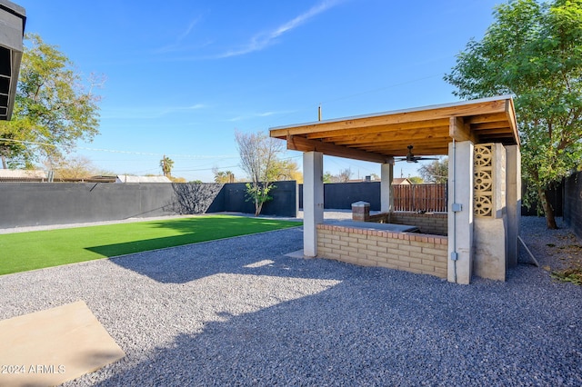 view of yard with ceiling fan and a patio