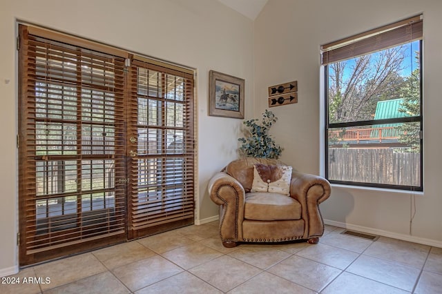 sitting room featuring light tile patterned floors and lofted ceiling