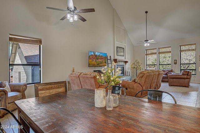 dining space with light tile patterned floors, high vaulted ceiling, and ceiling fan