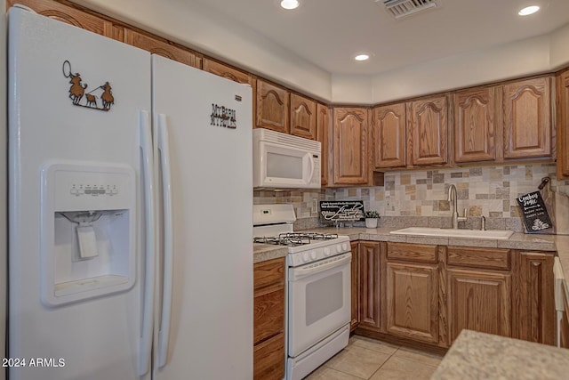 kitchen featuring decorative backsplash, white appliances, sink, and light tile patterned floors