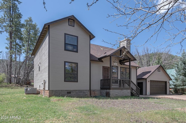 view of front of house with a garage, an outdoor structure, a front yard, and central AC