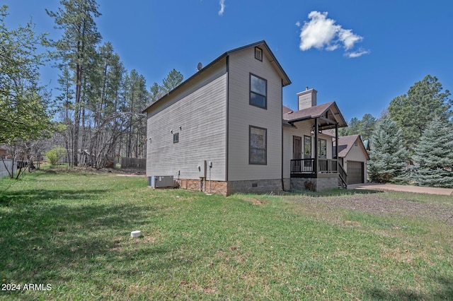 view of side of property with a lawn, a garage, and central AC