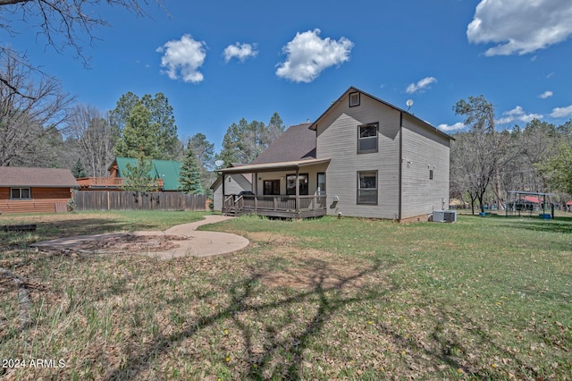 rear view of house with a yard and central AC