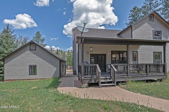 rear view of house featuring covered porch and a lawn