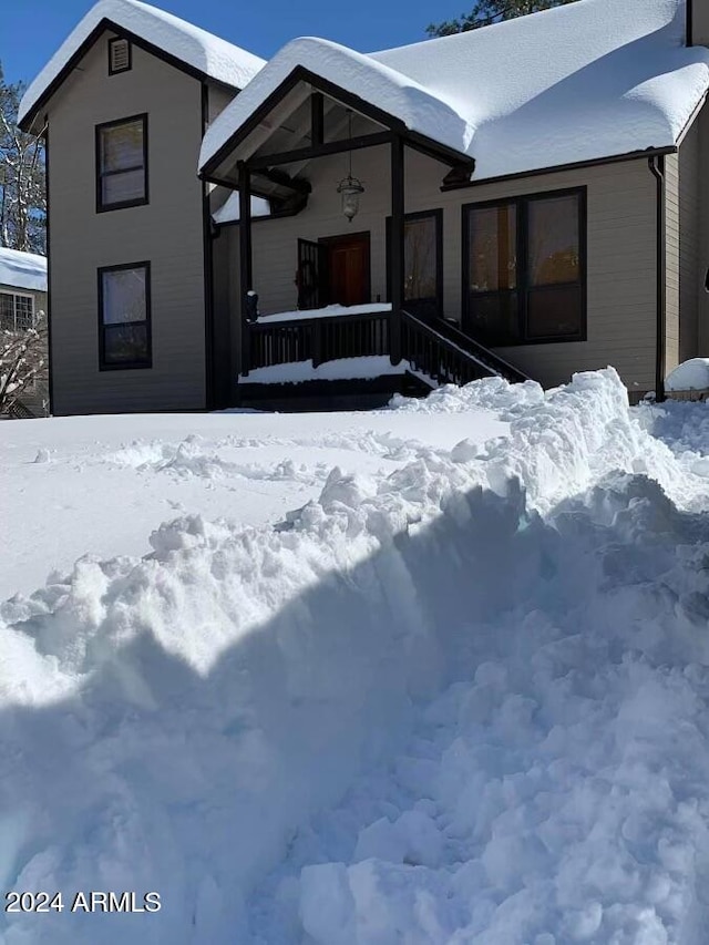 view of snow covered rear of property