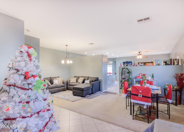 living room featuring ceiling fan with notable chandelier and light carpet