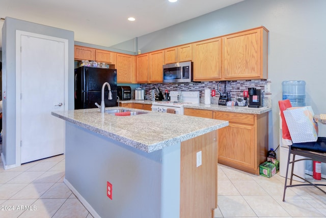 kitchen featuring electric range, sink, tasteful backsplash, black fridge, and a center island with sink