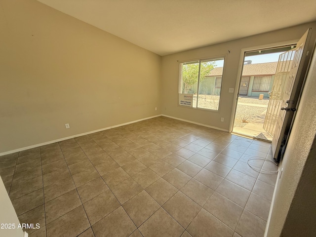 tiled spare room featuring baseboards