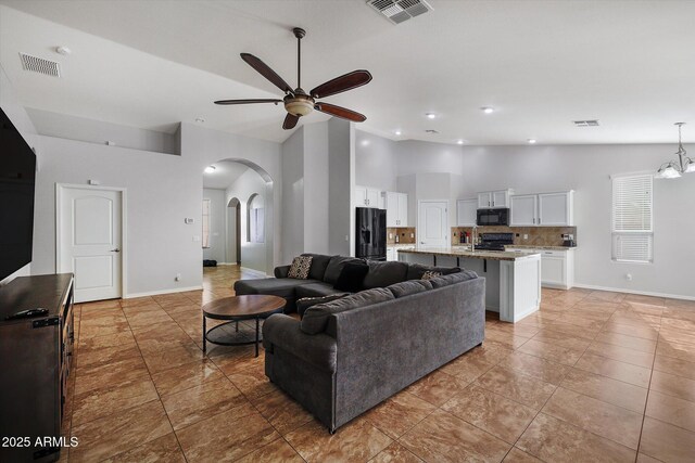 3592 E Sandwick Dr, San Tan Valley, AZ 85140 - living area featuring arched walkways, ceiling fan with notable chandelier, baseboards, and visible vents
