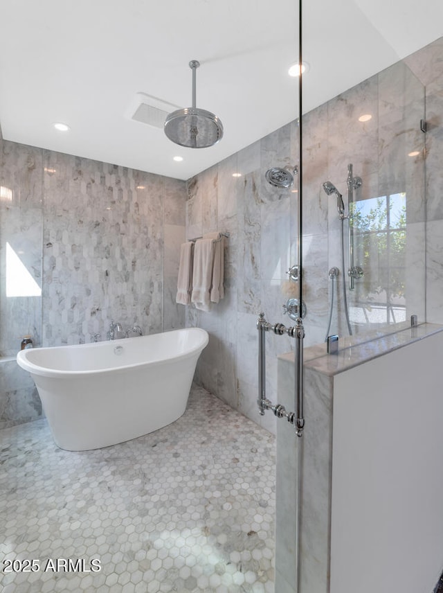 bathroom with tile patterned flooring, tile walls, and independent shower and bath