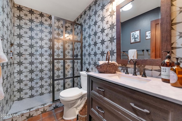 bathroom with a tile shower, toilet, tile patterned flooring, and vanity