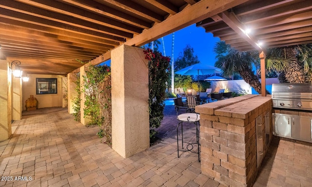 view of patio / terrace with a bar, exterior kitchen, and grilling area