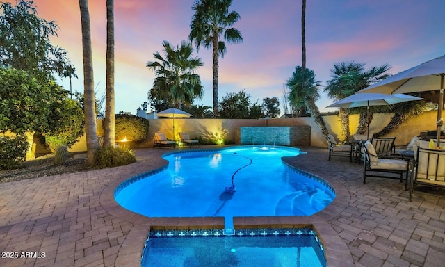 pool at dusk featuring a patio area