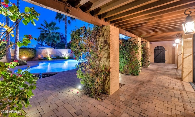 pool at night with a patio area