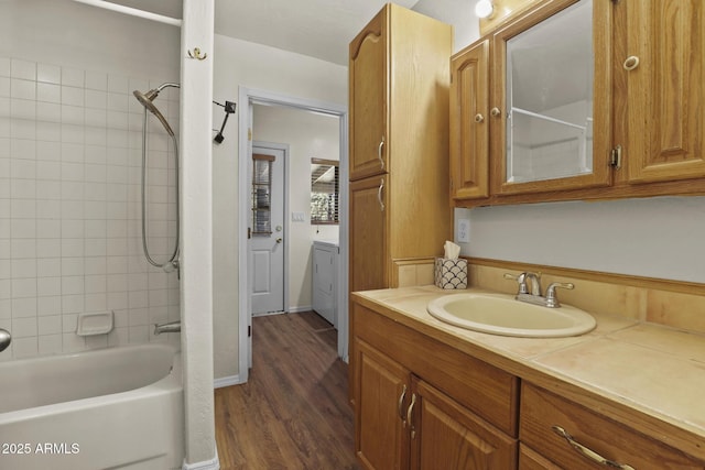 bathroom featuring vanity, washer / dryer, wood-type flooring, and tiled shower / bath